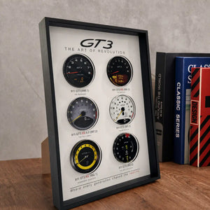 Porsche 911 GT3 Tachometer Evolution 3D Framed Display — standing on a wood desk beside books, showing 3D layered depth