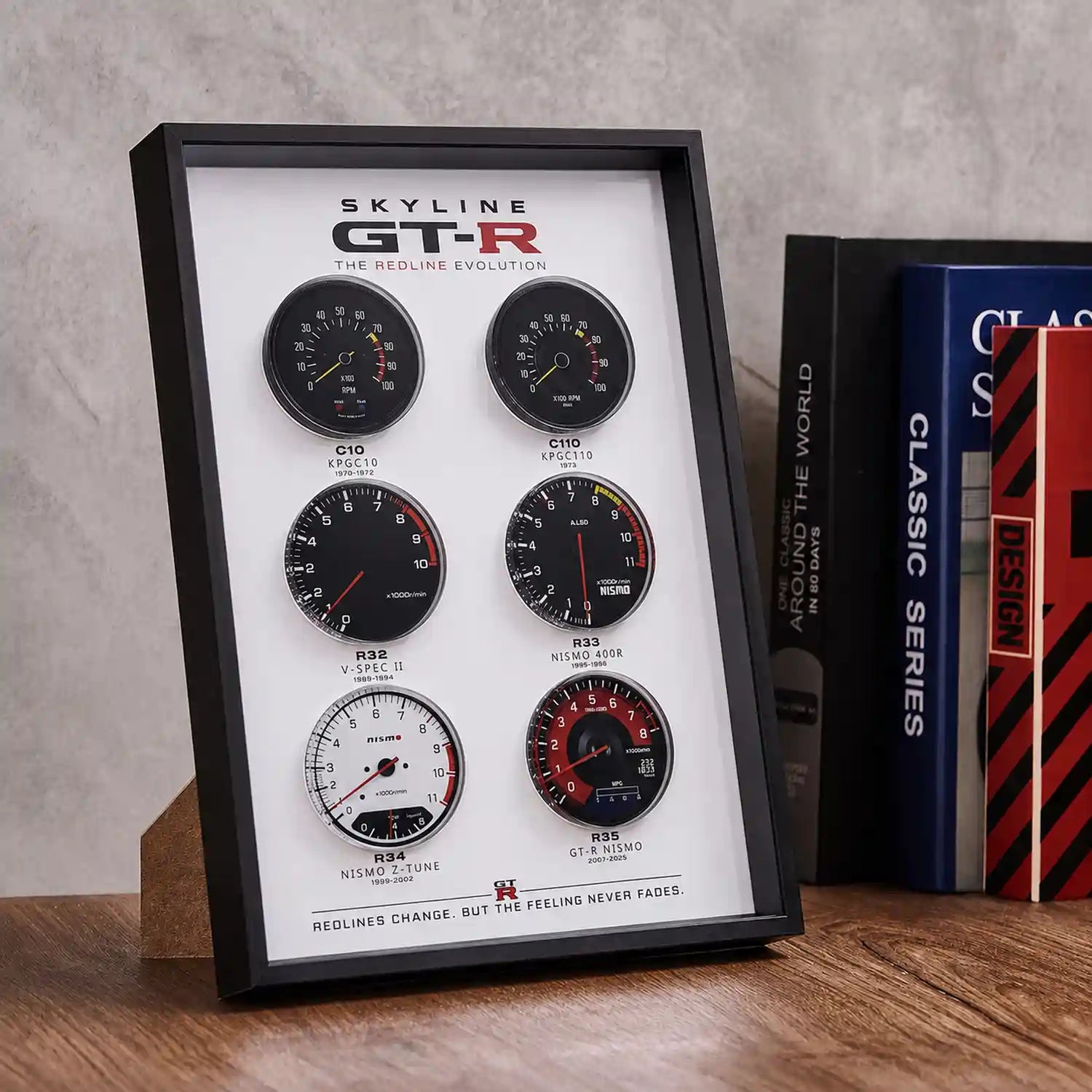 Nissan Skyline GT-R Tachometer Evolution 3D Framed Display — standing on a wood desk beside books, showing 3D layered depth