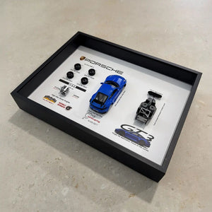 Porsche 911 GT3 992 Shark Blue Deconstructed Frame — laid flat on pale stone at an angle, showing the depth of the shadow box
