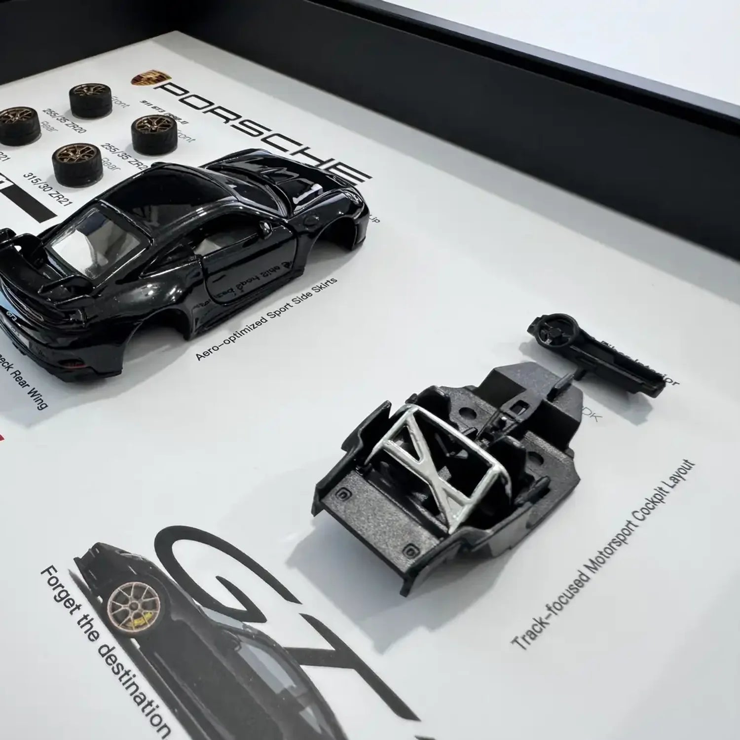 Porsche 911 GT3 992 Deconstructed Frame — macro detail of the body shell, roll cage chassis and swan-neck rear wing